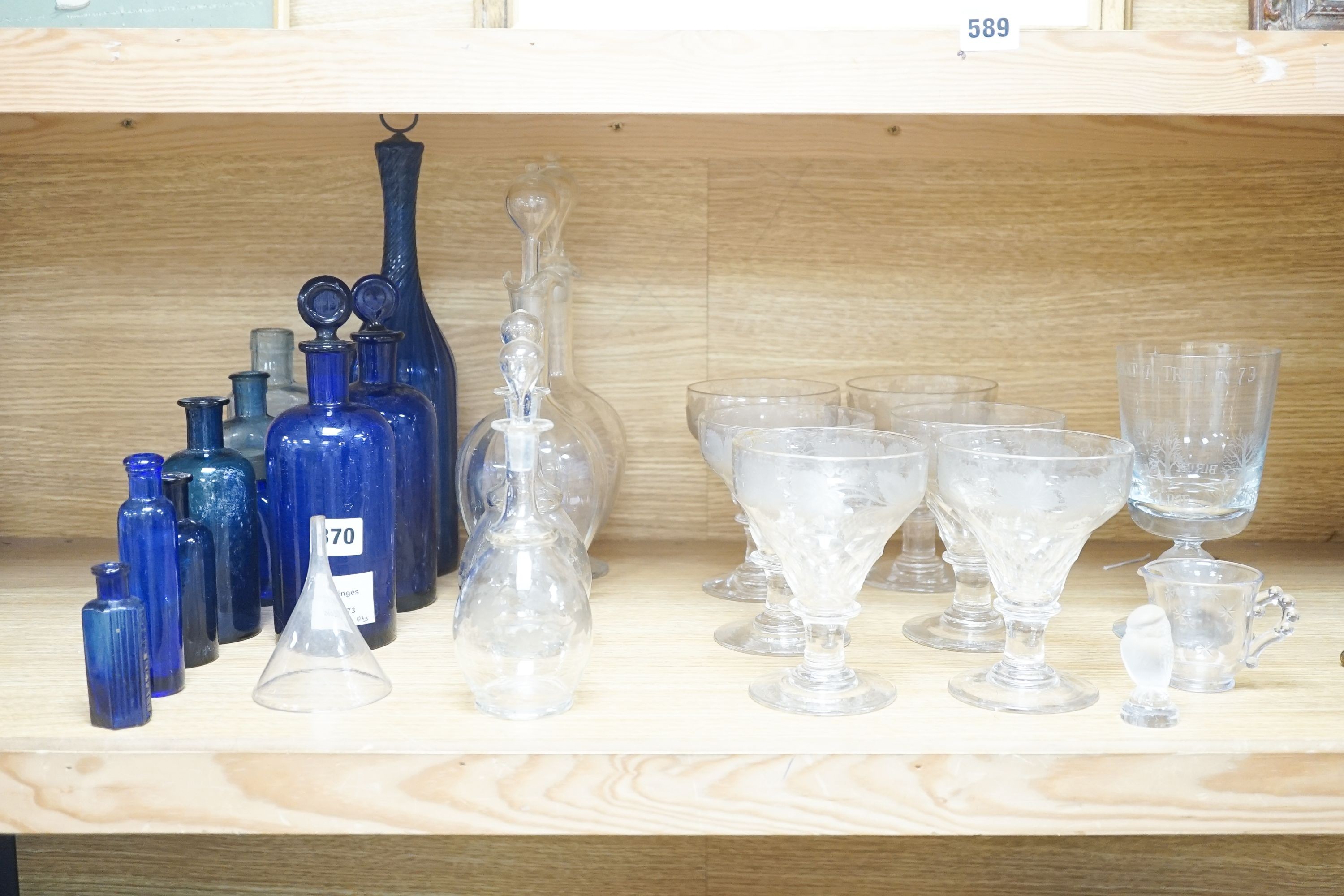 A Lalique frosted glass bird, etched Wedgwood ‘plant a tree ‘73’ glass, other etched glasses, decanters and blue glass pharmacy bottles